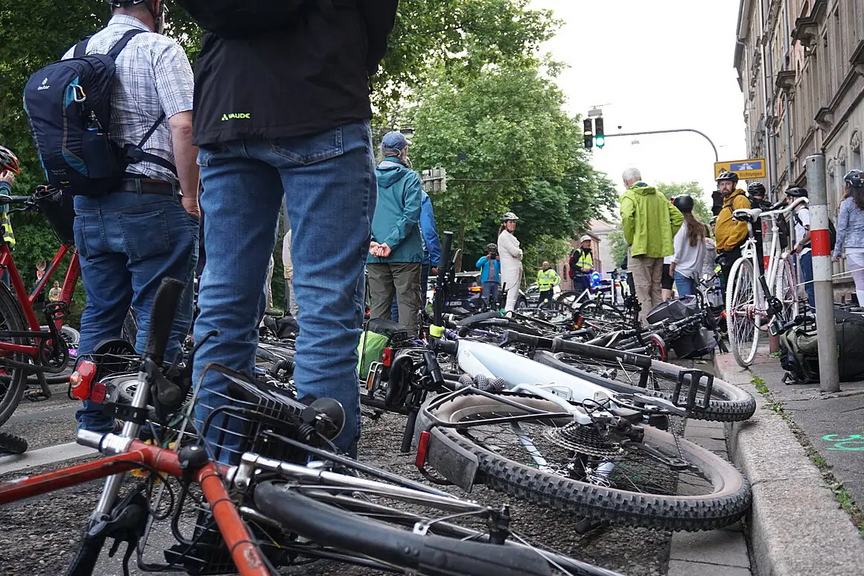 Ride of Silence am 21. Mai 2025 in Karlsruhe, Bikedown in der Kapellenstraße In der Kapellenstraße legen Radfahrende ihre Fahrräder am Unfallort nieder. Blick aus Kniehöhe vom Bordstein aus. Am Bordstein steht das Ghostbike.