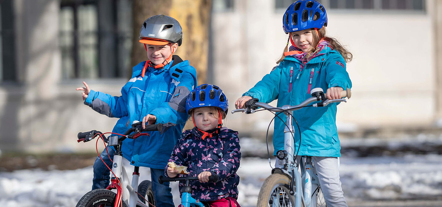 Kinder unterschiedlichen Alters auf dem Rad Drei Kinder in unterschiedlichem Alter auf Fahrrädern.