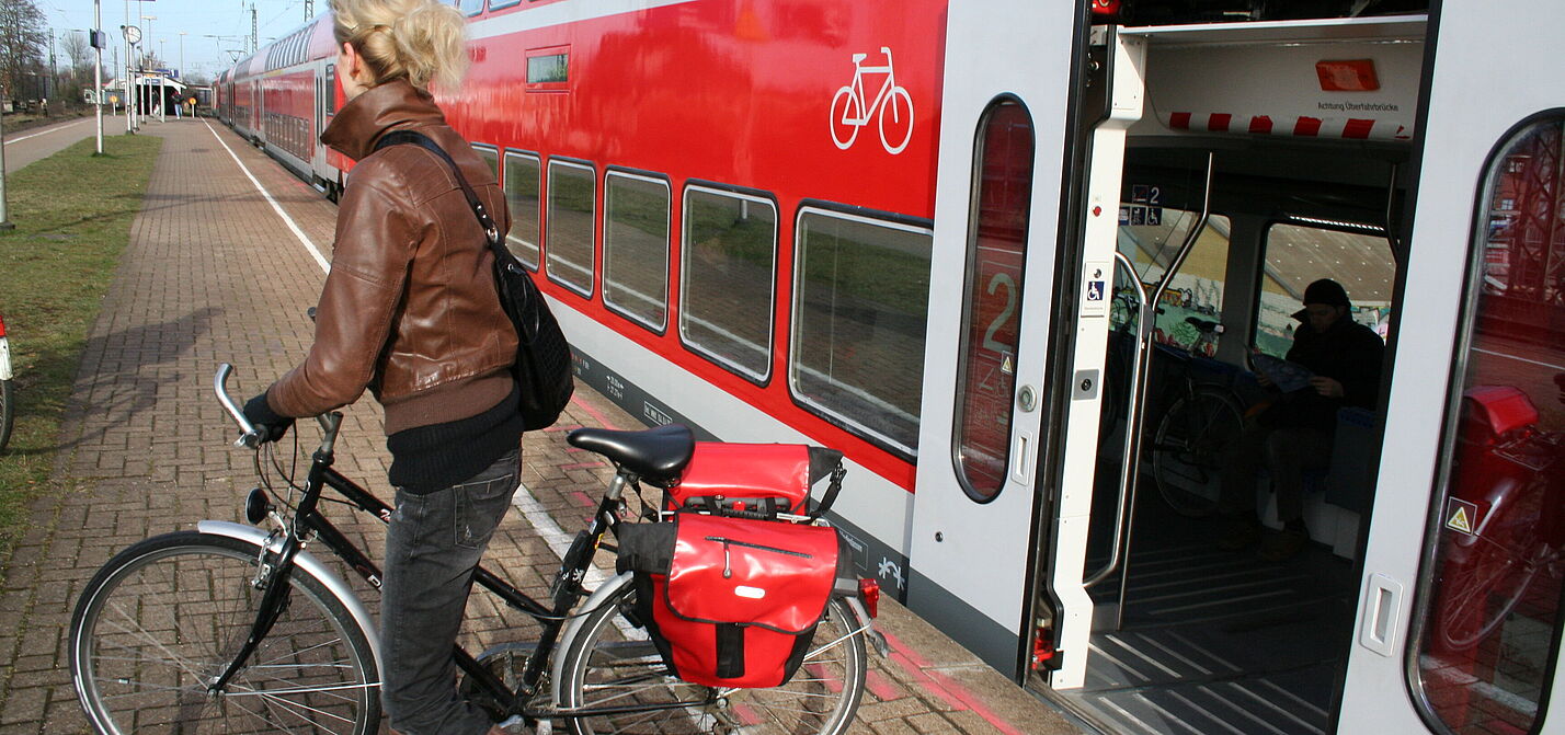 Fahrradmitnahme in der Bahn Frau mit Rad steigt aus Regionalzug